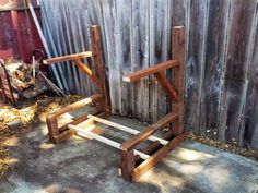 a wooden chair sitting in front of a fence