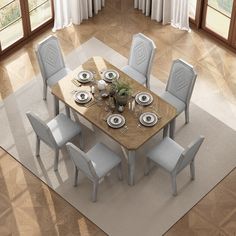 a dining room table with chairs and plates on it