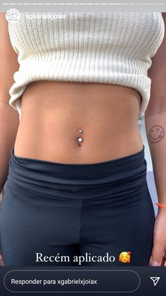 a woman's stomach with a small piercing on the middle part of her belly