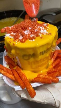 a yellow cake sitting on top of a white plate covered in cheese and toppings