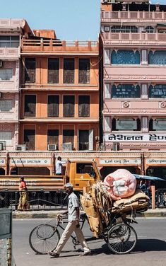 a man walking down the street next to a horse and buggy in front of some buildings