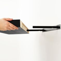 a hand is holding a piece of paper and pulling it out of a box with two black handles