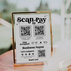 a scan - pay sign sitting on top of a wooden table