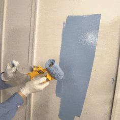 a person in blue gloves painting a wall