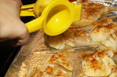 someone is grating chicken on foil with a yellow spatula