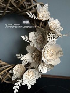 a wreath made out of book pages and paper flowers