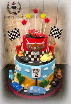 a birthday cake decorated with cars and flags