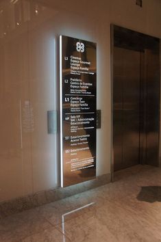 an elevator with glass doors and signs on the wall