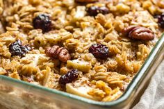 a casserole dish filled with granola, nuts and cranberries