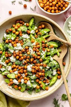 a bowl filled with chickpeas, lettuce and feta cheese on top