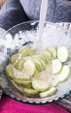 a bowl filled with sliced cucumbers on top of a table