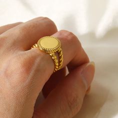 a person's hand holding a gold ring