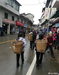 several people walking down the street carrying baskets