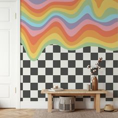 a room with a checkered wall and wooden table in front of it, next to a white door