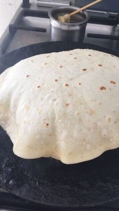 an uncooked tortilla sitting on top of a stove