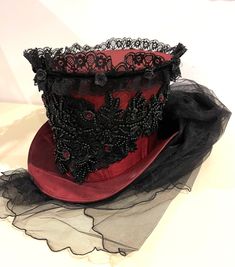 This is elegant Victorian gothic Hand made wine Maroon Top hat with black back beautifully hand crafted feathers and flowers black net bustle train. Top Hat with Black laces and 3D silk flowers and black pearls and dark red jewels and sequins hand stitched.  Please refer to the photos. This is stunning Victorian Steampunk Handmade top hat made with lots of love. It is very well made, this hat is made of a satin type of fabric and the inside of the hat is has a Black satin  lining. The front of t Top Hat Women, Red Top Hat, Black And Red Roses, Odd Fashion, Lampshade Makeover, Maroon Top, Victorian Hats, Red Jewel, Satin Noir