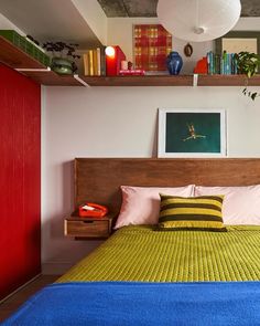 a bedroom with a bed, shelves and pictures on the wall above it's headboard