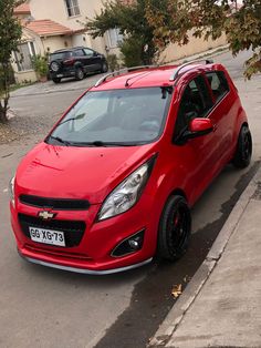 a red car is parked on the side of the road