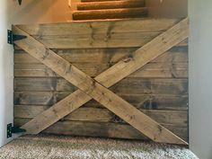 a wooden gate on top of a carpeted stair case next to a set of stairs