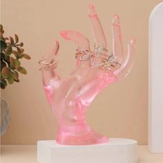 a pink hand statue on top of a white table