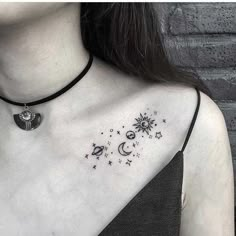 a woman wearing a black choker with stars and moon tattoos on her chest