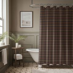 a bathroom with a bathtub, sink and shower curtain in plaid pattern on the wall