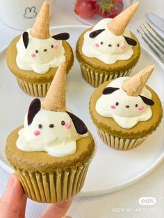 four cupcakes with white frosting on a plate