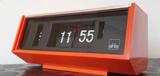 an orange clock sitting on top of a table