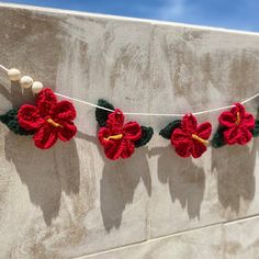 crocheted flowers are hanging on a string