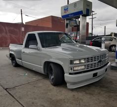 a white truck parked in front of a gas station