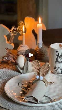 a white plate topped with two mugs filled with liquid next to candles and napkins