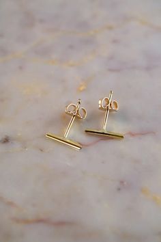 A mini version of the classic Bar Studs. Lightweight, modern bars are soldered to allergy-friendly posts then polished to a bright, shiny finish. Available in Solid 14K Gold or 14K Rose Gold. Select SINGLE or PAIR of studs. These bar stud earrings measure approx. 1/3" long. Each stud earring will come with an ear nut backing. Every piece is organic and unique — no two Hannah Naomi pieces are exactly alike.Hand-crafted to order in our Portland, OR studio. Modern Bars, Dramatic Necklace, Gold Bar Earrings Studs, Jewelry Design Studio, Classic Bar, Gold Bar Earrings, Black Gold Jewelry, Bar Stud Earrings, Bar Studs