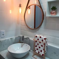 a white sink sitting under a bathroom mirror next to a faucet mounted on a wall