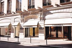 an empty street in front of a building with chandeliers on the windows and awnings