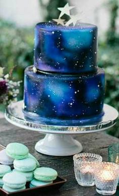 a blue cake sitting on top of a wooden table