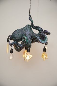 an octopus chandelier with three lights hanging from it's sides and two bulbs on each side