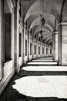 black and white photograph of an arched walkway with light coming through the arches on both sides