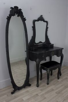 an antique vanity with mirror and stool in a room