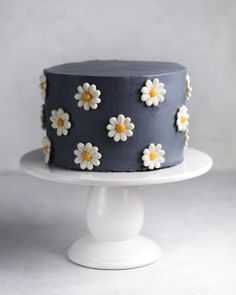 a blue cake with white and yellow flowers on it