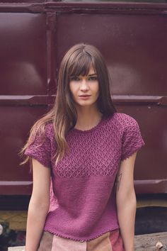 a woman with long hair wearing a purple top