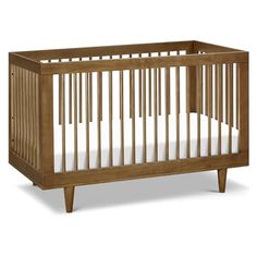 a wooden crib with white sheets on the bottom and wood trim around the sides