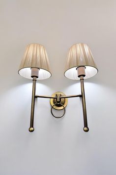 two lamps mounted on the wall next to each other with one light on it's side