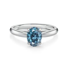 a white gold ring with a blue topazte stone in the center and a thin band