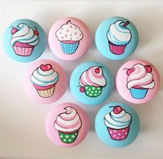 six different colored cupcakes on pink and blue buttons