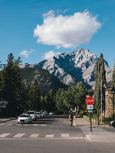 a stop sign at an intersection with mountains in the background