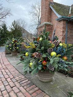 a potted plant with pine cones and evergreens on the side of a brick building