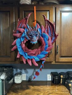 a dragon wreath is hanging on the kitchen cabinets