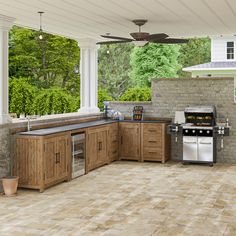 an outdoor kitchen with wood cabinets and tile flooring on the outside wall, along with a ceiling fan