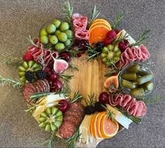 a circular arrangement of fruits and meats arranged in the shape of a circle on a table