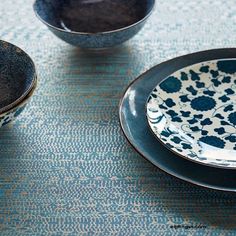 two black and white plates sitting next to each other on a tablecloth covered table